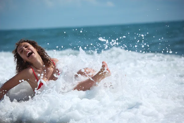 Schoonheid meisje zit in zee surf — Stockfoto