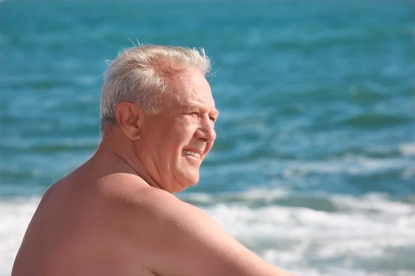 Sahil üzerinde gülümseyen yaşlı adam — Stok fotoğraf