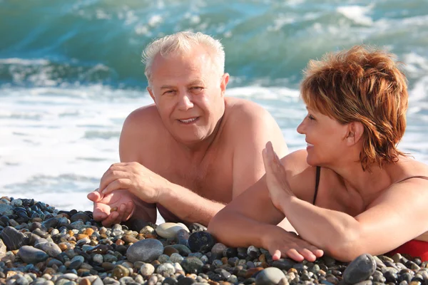 Äldre par Ligg på pebble beach — Stockfoto