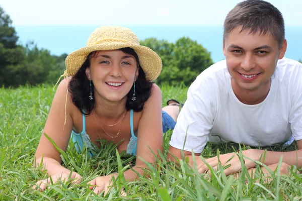 Mladý pár leží na trávě — Stock fotografie