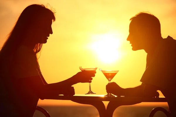 Hombre y mujer clink gafas en la puesta del sol fuera —  Fotos de Stock