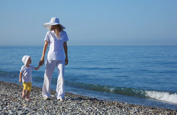 Moeder met kind wandeling op de rand van de zee — Stockfoto