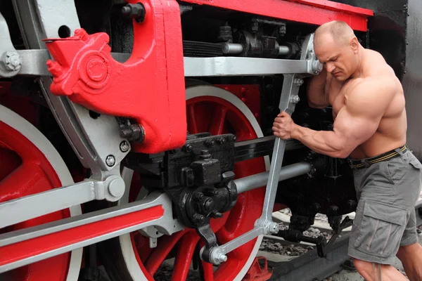 Спортсмен перевіряє стан локомотива — стокове фото