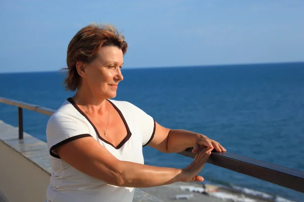 Портрет женщины среднего возраста на балконе над морем — стоковое фото