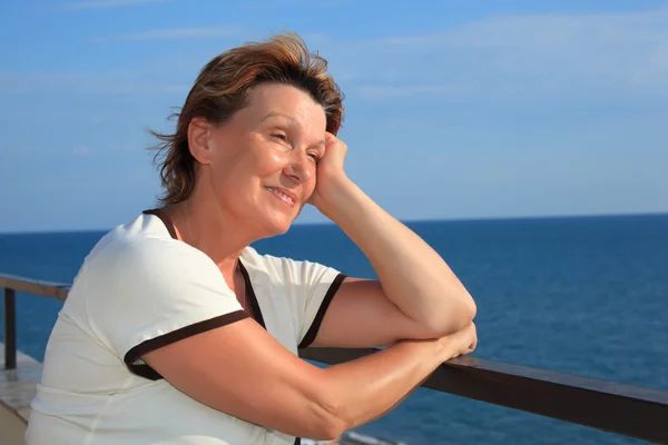 Porträtt av medelålders kvinna på balkong över havet — Stockfoto