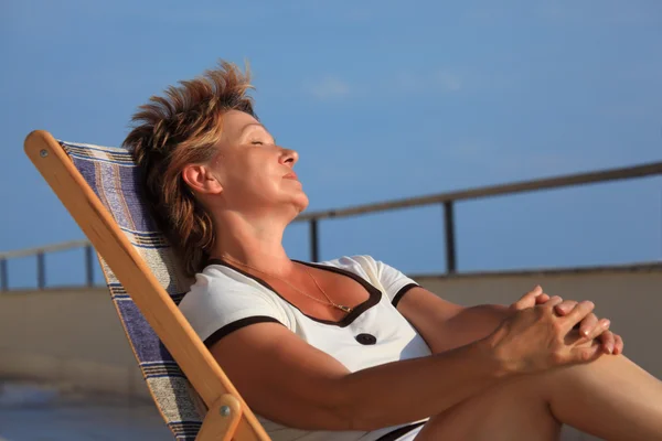 Sonhando mulher de meia idade no salão na varanda sobre o mar — Fotografia de Stock