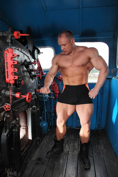Athlete in locomotive cabin full body — Stock Photo, Image