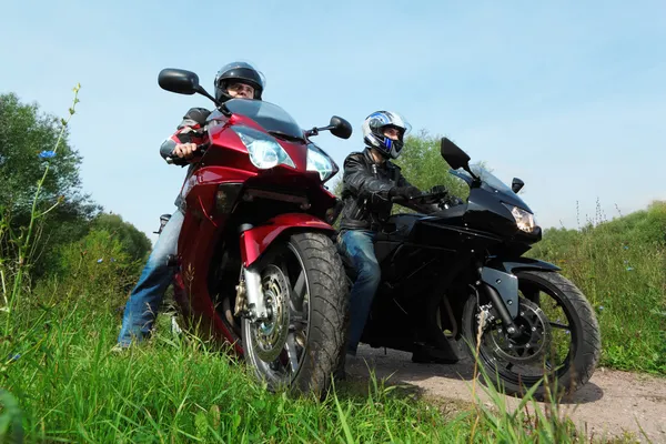 Deux motocyclistes debout sur la route de campagne, vue du bas — Photo