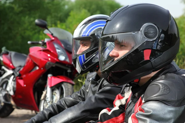 Closeup of two motorcyclists sitting on country road near bikes — Stock Photo, Image
