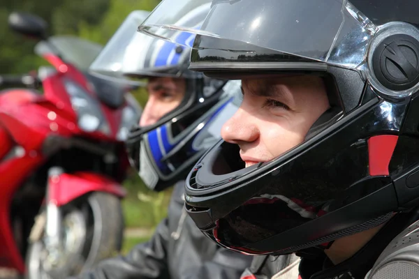 Portrait of two motorcyclists sitting on country road near bike — Stock Photo, Image