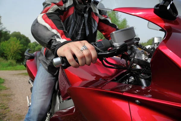 Mão de motociclista na estrada de campo — Fotografia de Stock