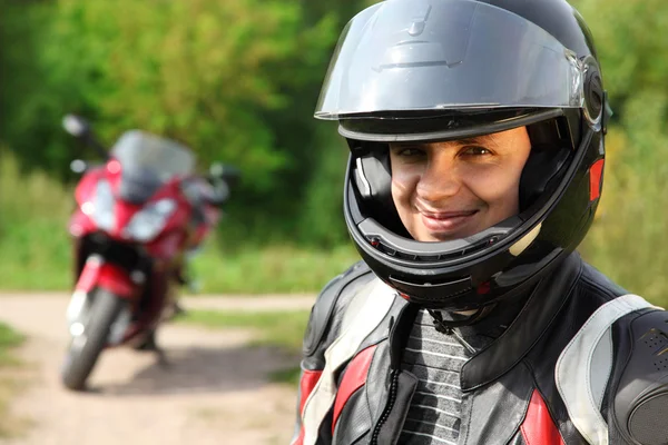 Motociclista e la sua moto su strada di campagna — Foto Stock