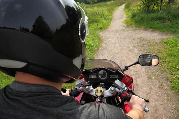 Motorcyclist on country road, view because of shoulder — Stock Photo, Image