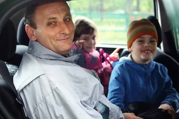 Homme et enfants assis dans la voiture — Photo