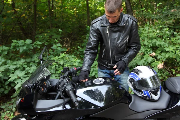 Motociclista e la sua moto nel bosco — Foto Stock