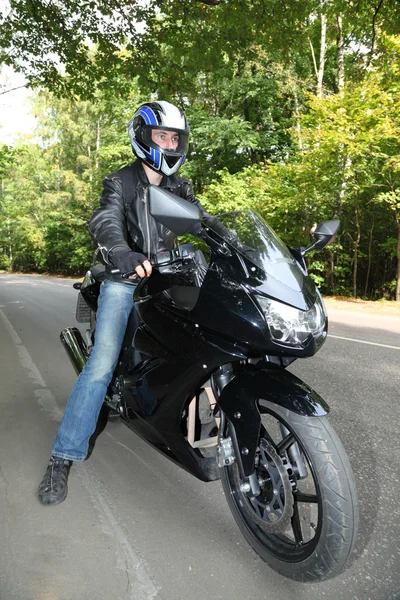 Motocyklista stojící na silnici — Stock fotografie