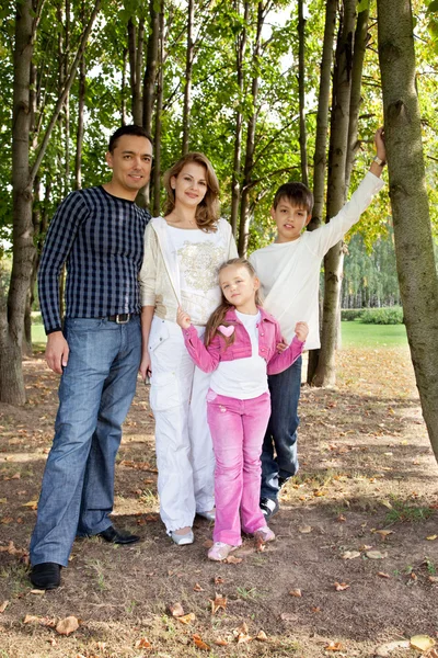 Smiling happy family of four in park — Stock Photo, Image