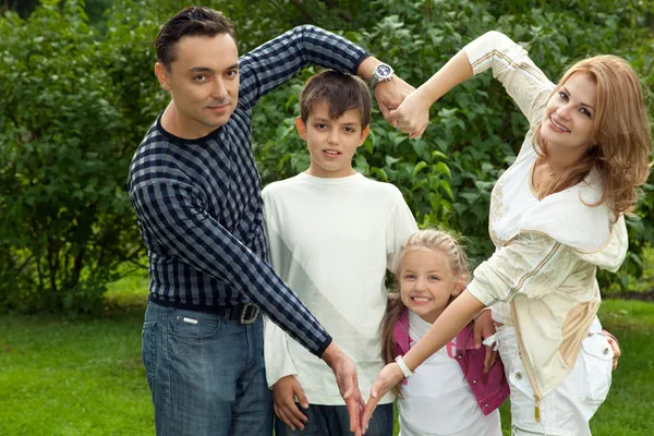 Açık havada eliyle aile yapım kalp simgesi — Stok fotoğraf