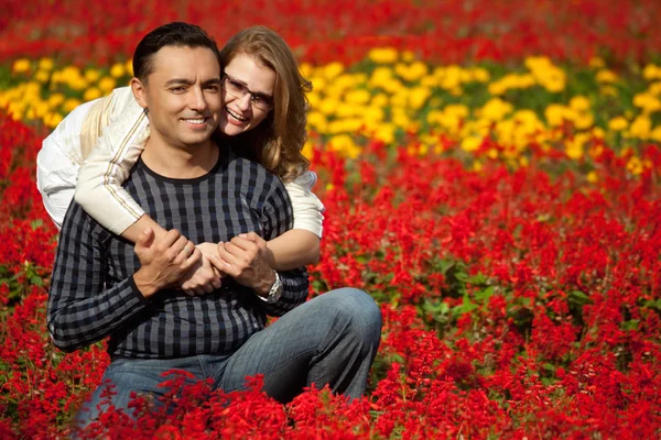 Homem e mulher entre parênteses rindo nas flores — Fotografia de Stock