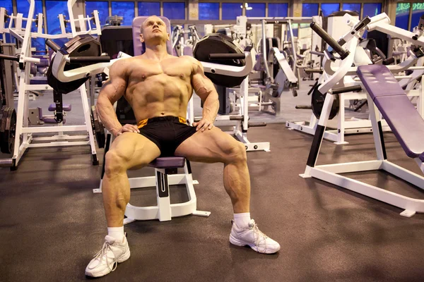 Bodybuilder berust in trainingsruimte — Stockfoto