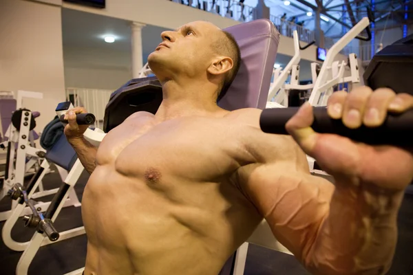 Bodybuilder sideways doing weightlifting in gym — Stock Photo, Image