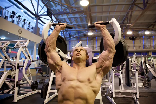 Fisiculturista fazendo levantamento de peso no ginásio — Fotografia de Stock