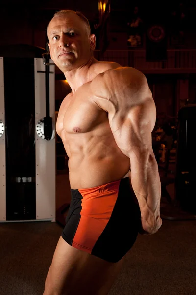 Fisiculturista demonstra seus músculos — Fotografia de Stock