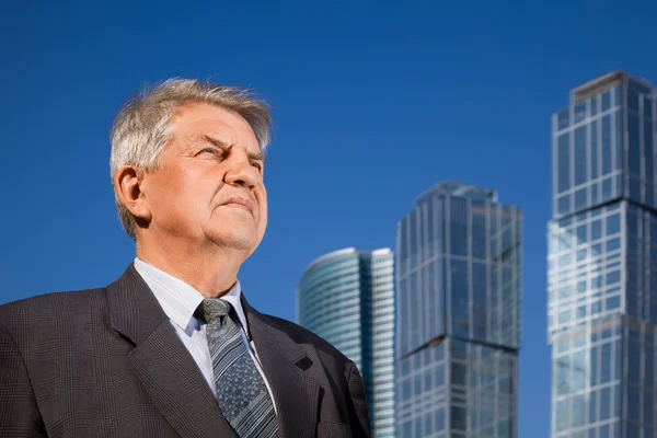 Senior mannen nära skyskrapor konstruktion — Stockfoto