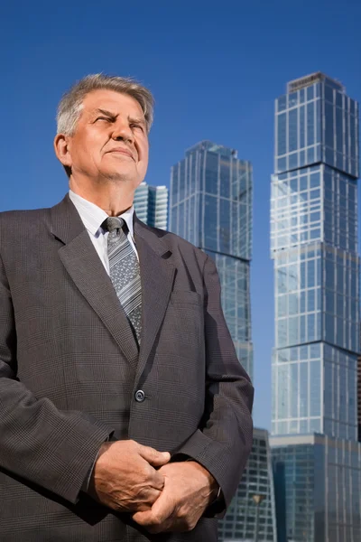 Senior man in de buurt van wolkenkrabbers bouw — Stockfoto
