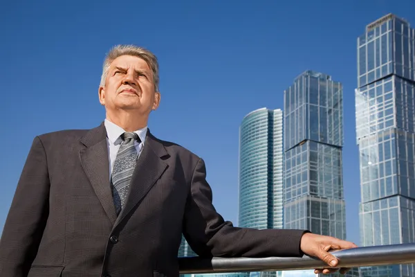 Homem sênior perto de arranha-céus construção — Fotografia de Stock