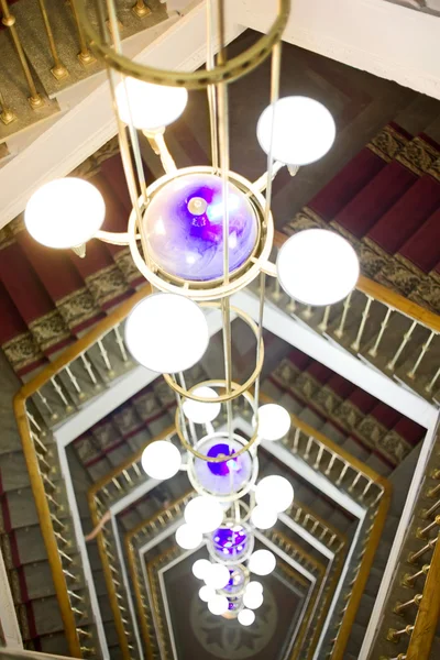Hermosa lámpara de araña contra una escalera —  Fotos de Stock