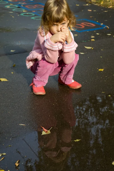 Petite fille s'asseoir près de la piscine après la pluie — Photo