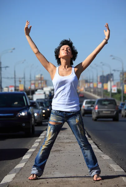 Chica se para en medio de la carretera con las manos levantadas —  Fotos de Stock