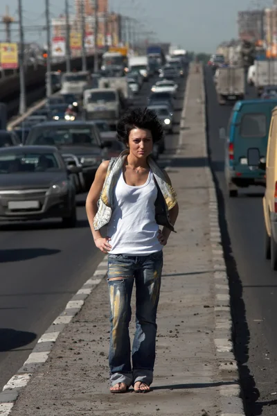 Chica en medio de la carretera en la ciudad — Stok fotoğraf