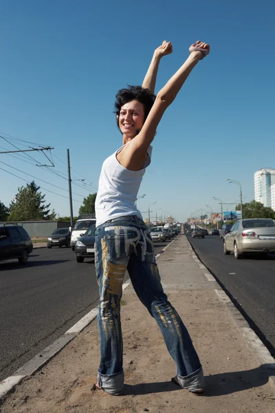 Chica con las manos levantadas se para en medio de la vuelta en medio de la carretera amo —  Fotos de Stock