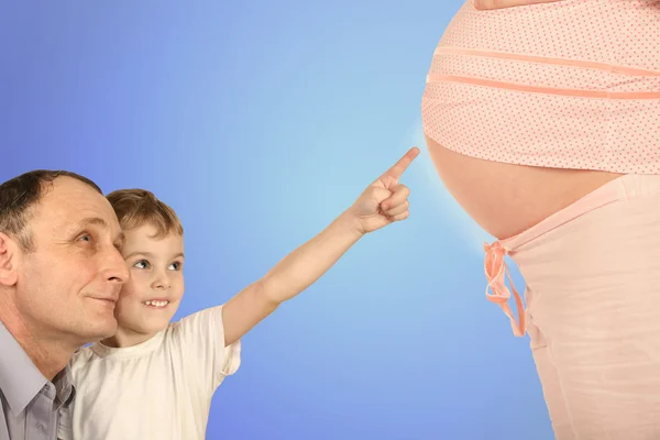 Мальчик со старшим, указывая на беременный коллаж живота — стоковое фото