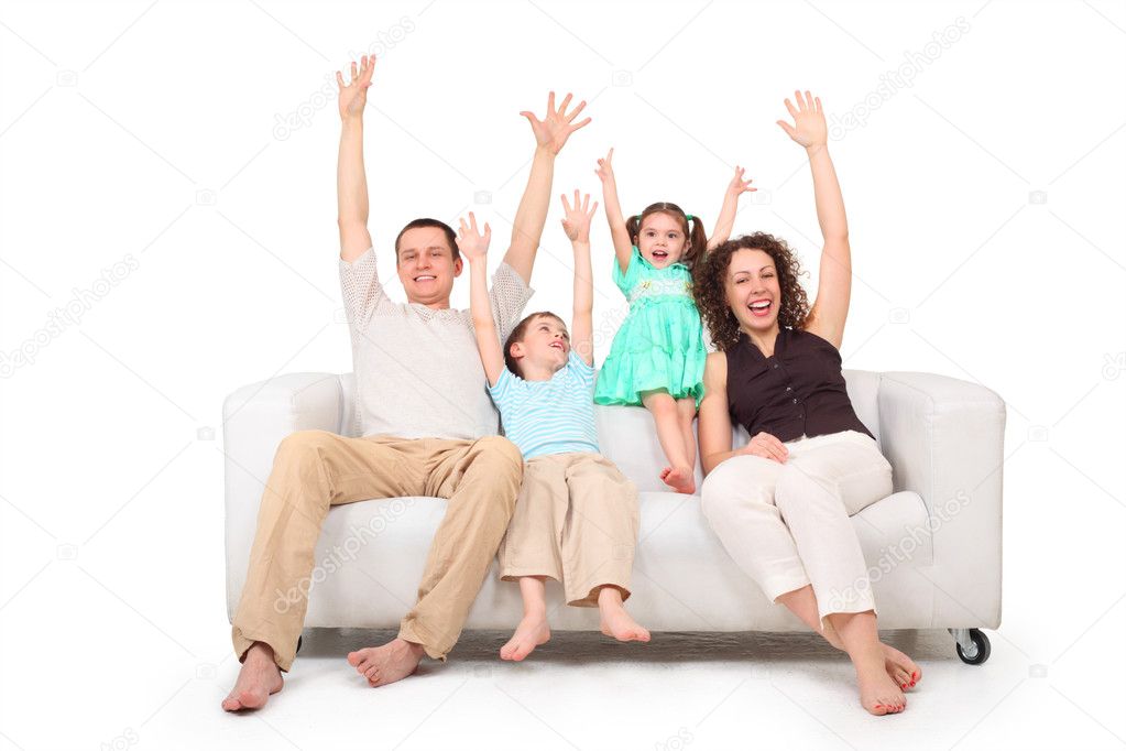 Parents and children with rised hands on white leather sofa
