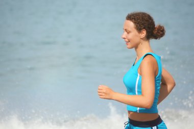 Woman is making exercise on sea coast clipart