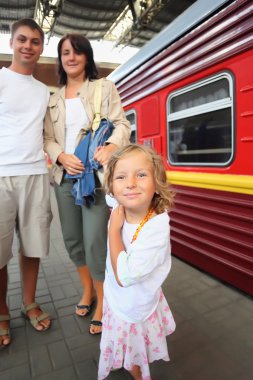 Happy family with little girl at railway station, focus on daugh clipart