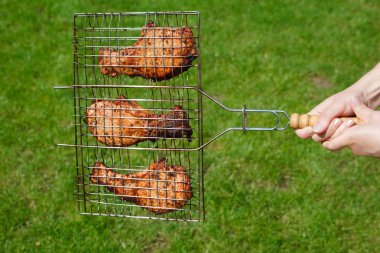 Hands hold a lattice with fried meat clipart