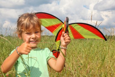 Little girl plays kite on meadow with ok gesture clipart