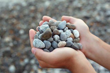 Handful of stones in hands, Against stones clipart