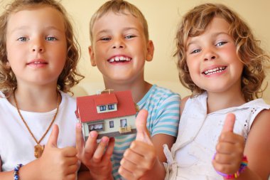 Children three together keeping in hands model of house in cosy clipart