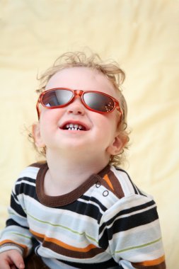 güneş gözlüklü çocuk yukarı bakar