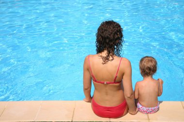 Mother and the daughter sit at pool clipart