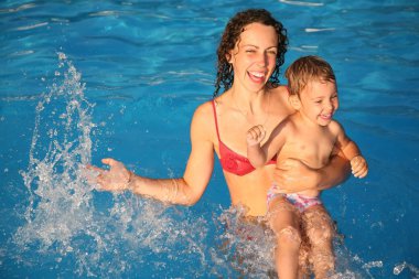 Mother with the child in the water clipart