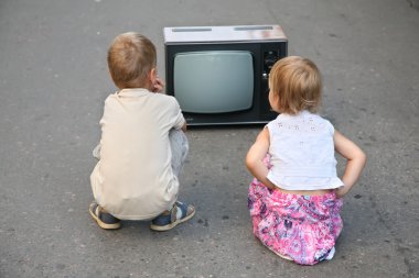 Children on the road in the old television set clipart