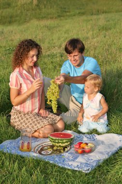 Parents with daughter on picnic clipart