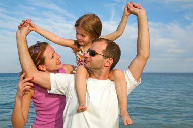 Mother, daughter and father on the sea clipart