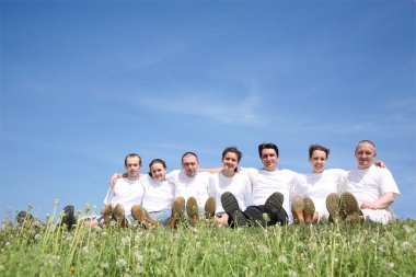Friends in white T-shorts have a rest on a grass clipart